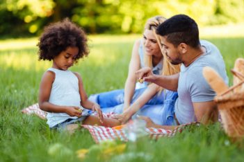 Picture of lovely couple with their daughter having picnic